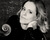 Portrait of Sol Gabetta. She leans next to her cello and looks into the camera.
