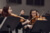 Zwei Bratschistinnen des Orchesters im Vordergrund. Im Hintergrund: Einige Orchestermitglieder.