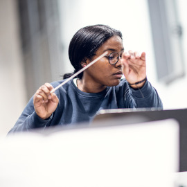 Junge Frau dirigiert.