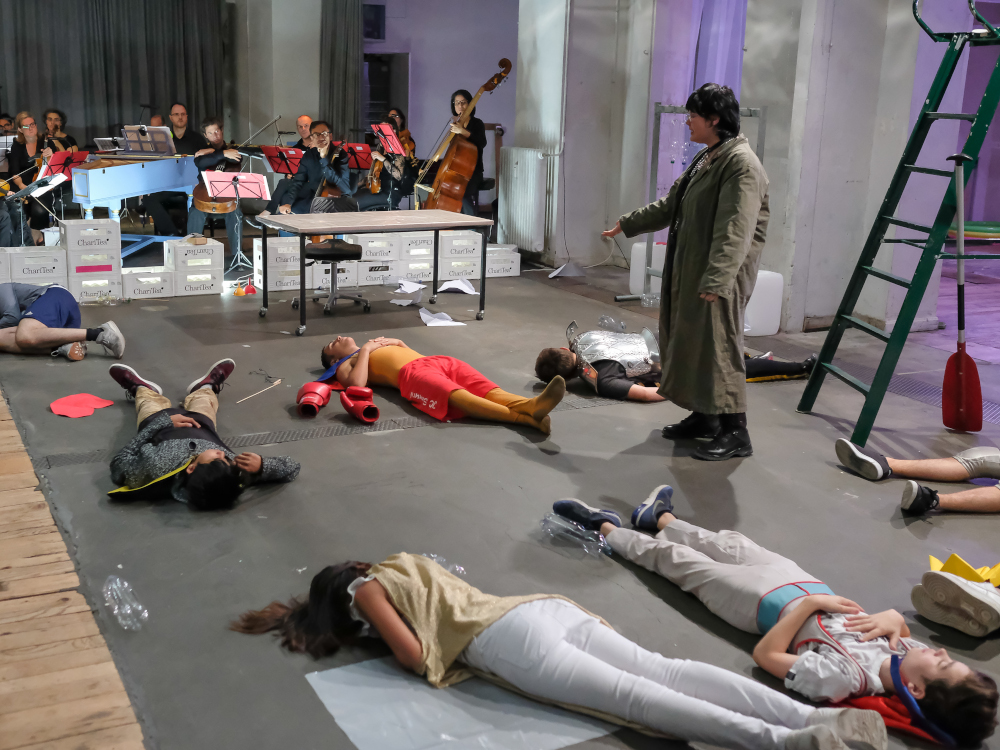 Kinder beim Theaterspielen, Orchester im Hintergrund