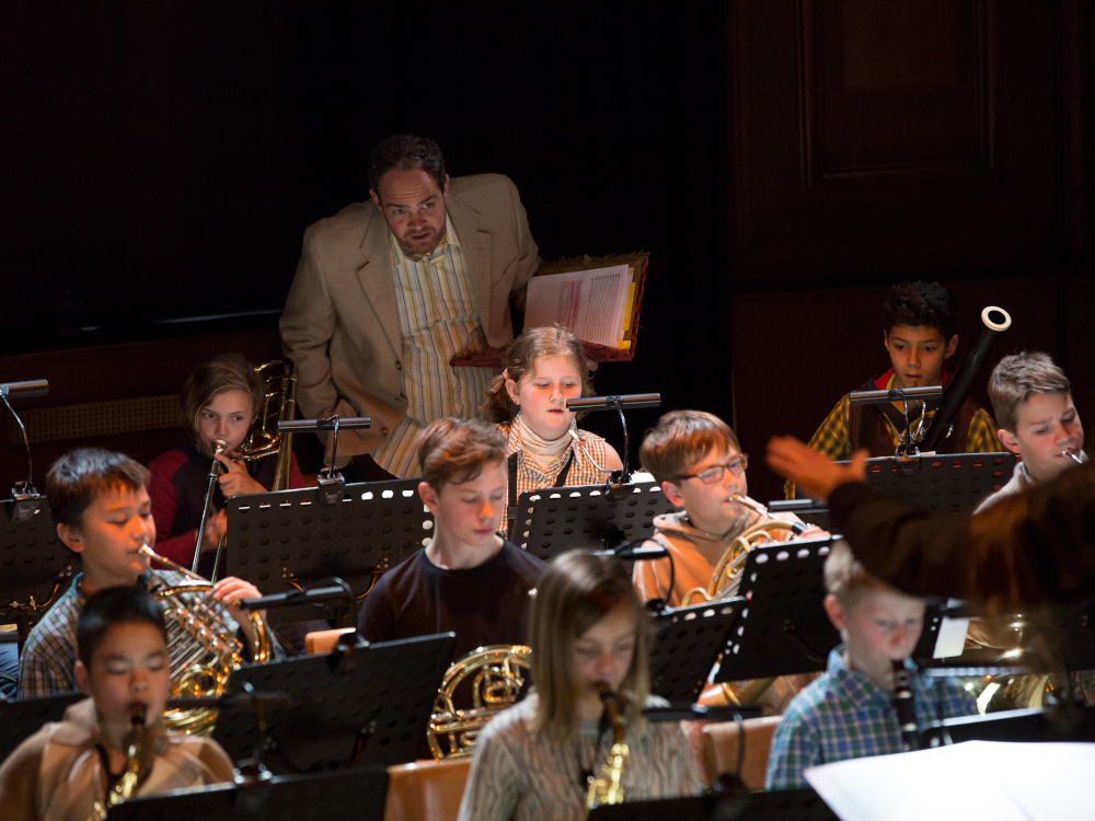 Blasorchester mit jungen Musiker:innen, Solist hinter dem Orchester