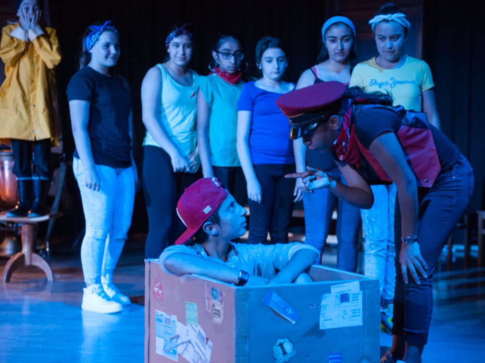 zwei junge Schauspieler:innen im Vordergrund diskutieren