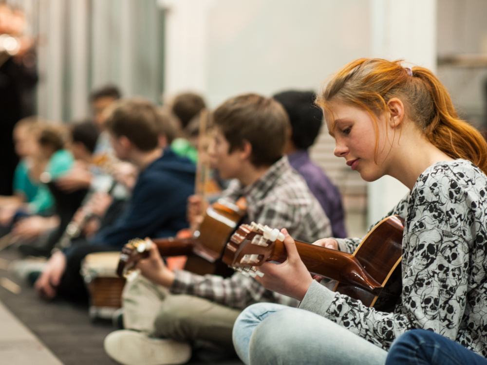 Portrait Mädcen spielt Gitarre