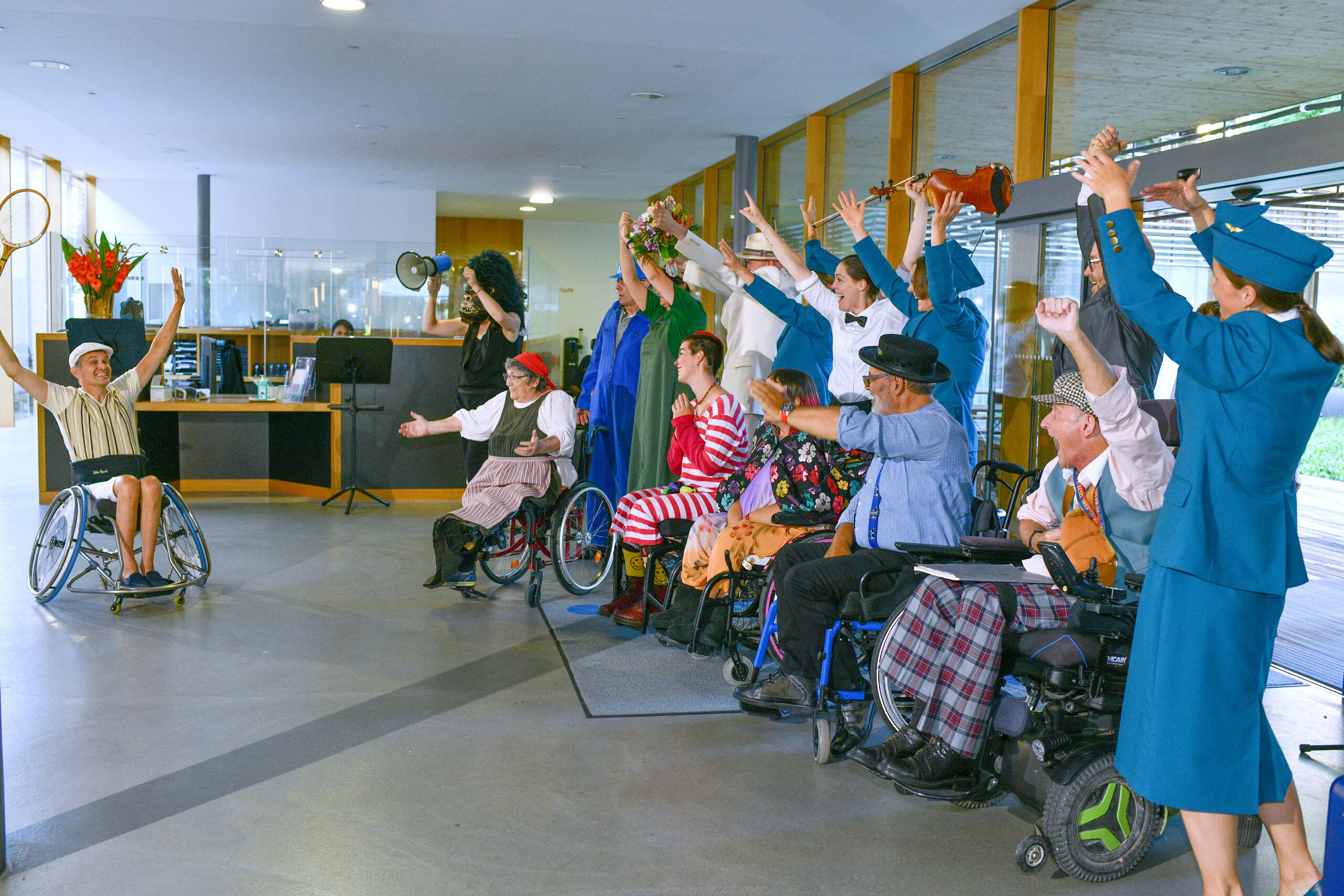 Gruppe von Darsteller:innen und Musiker:innen streckt jubelnd die Hände in die Luft