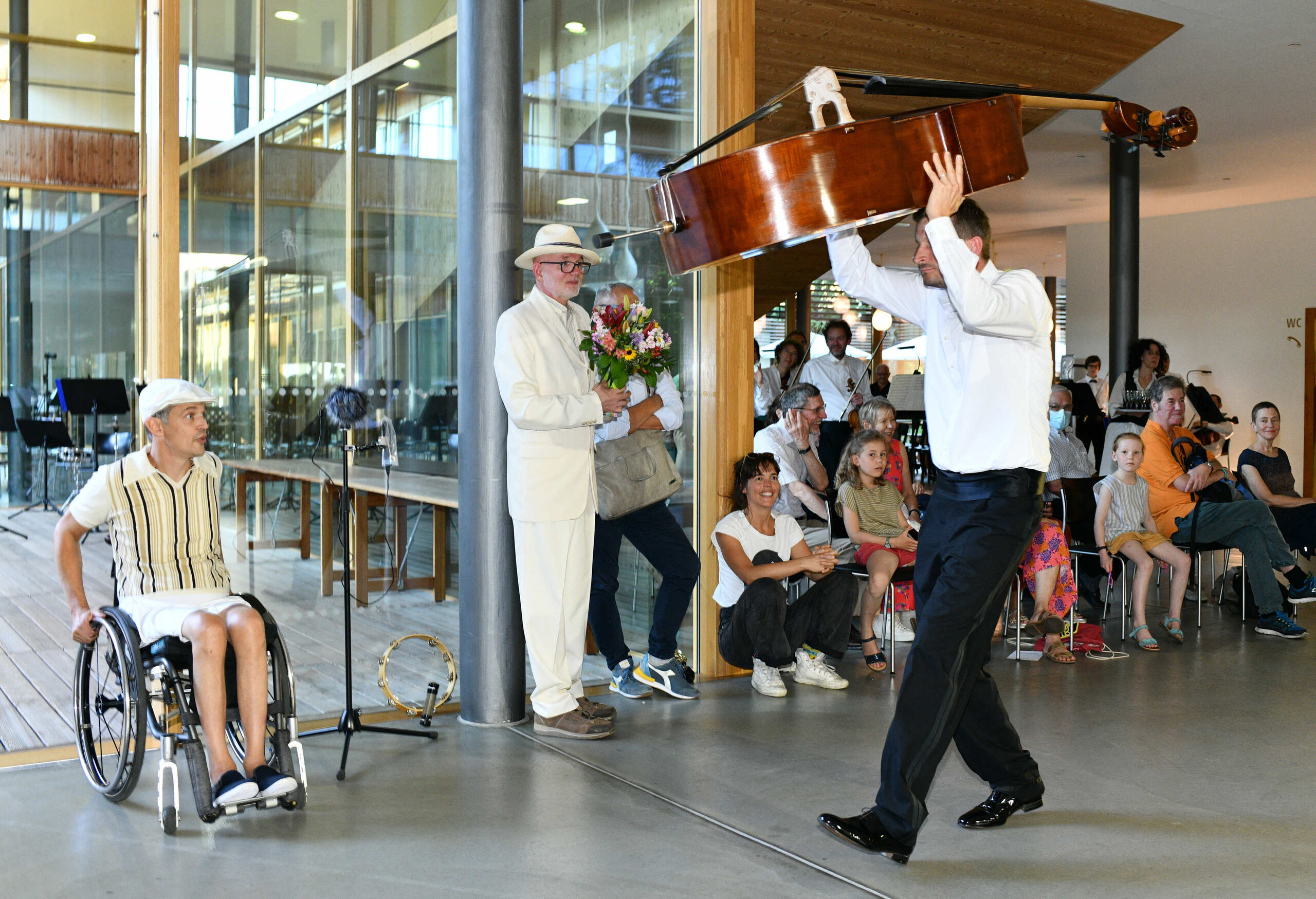 Kontrabassist trägt sein Instrument über dem Kopf über die Bühne