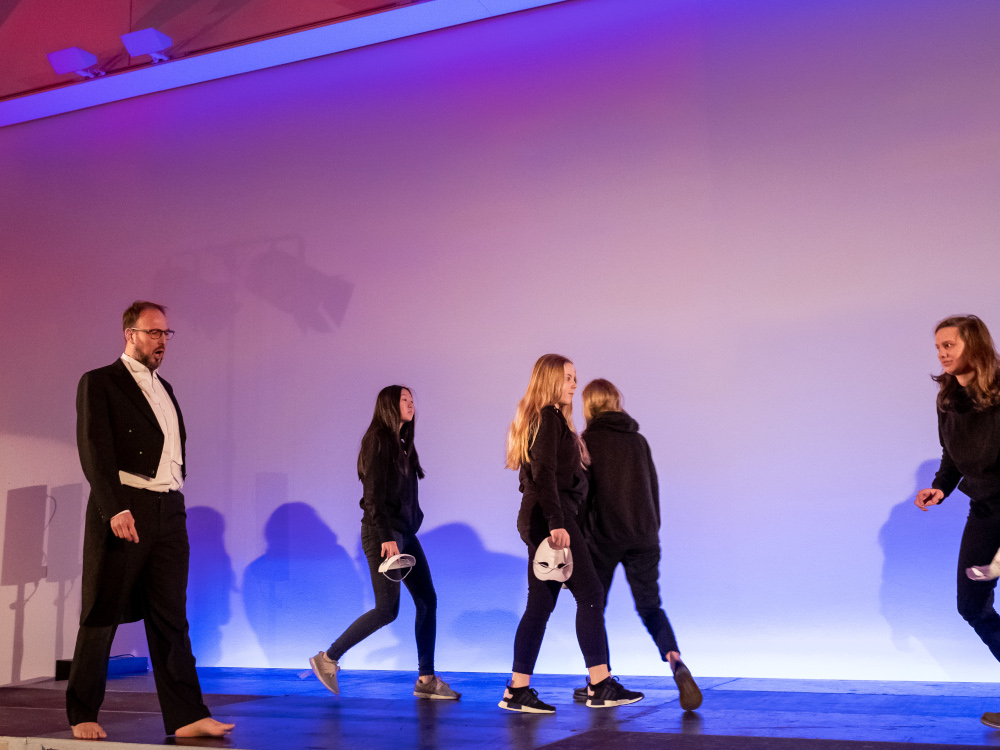 vier junge Darstellerinnen und ein Solist gehen auf und ab