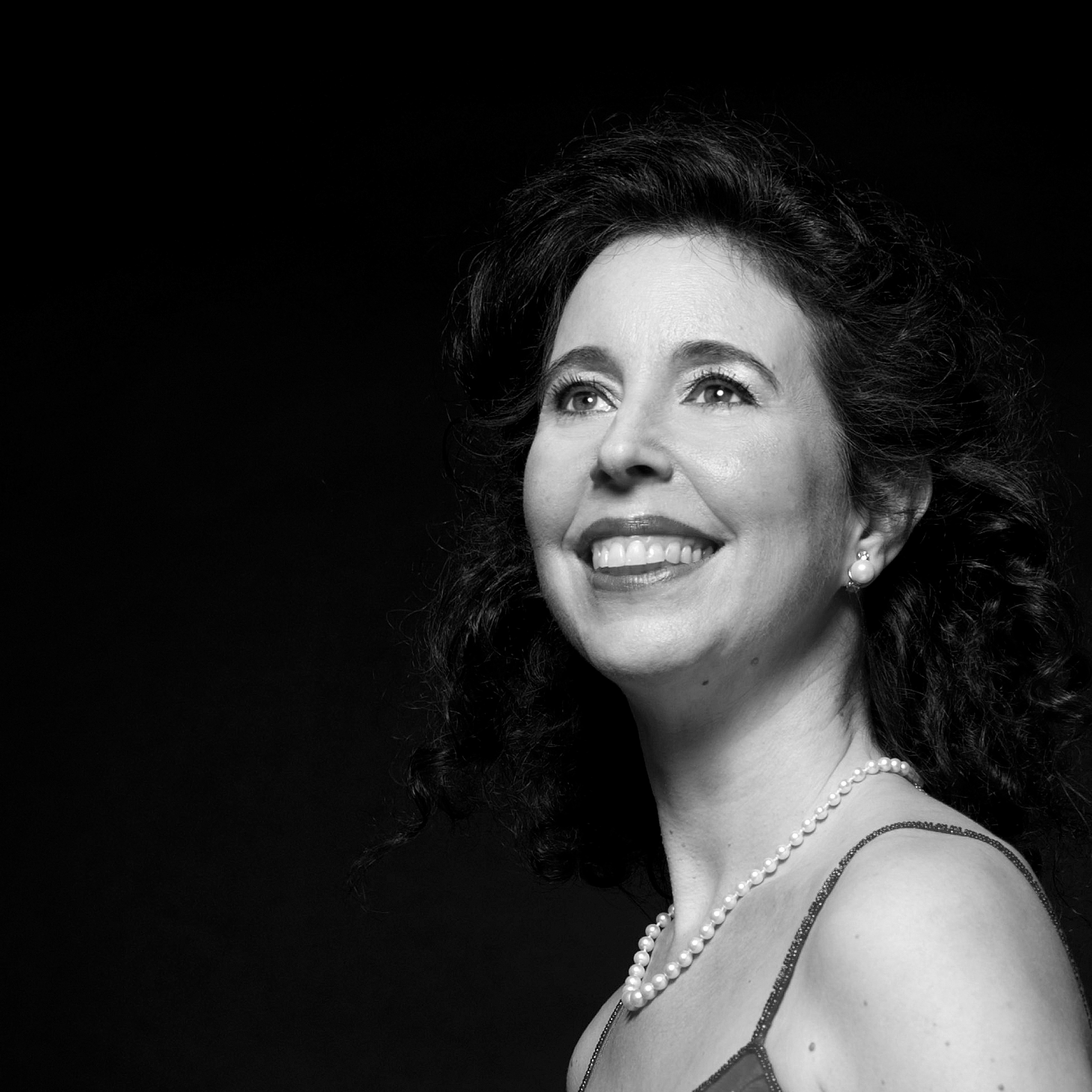 Ein Portrait der Pianistin Angela Hewitt. Sie lacht und schaut schräg nach oben.