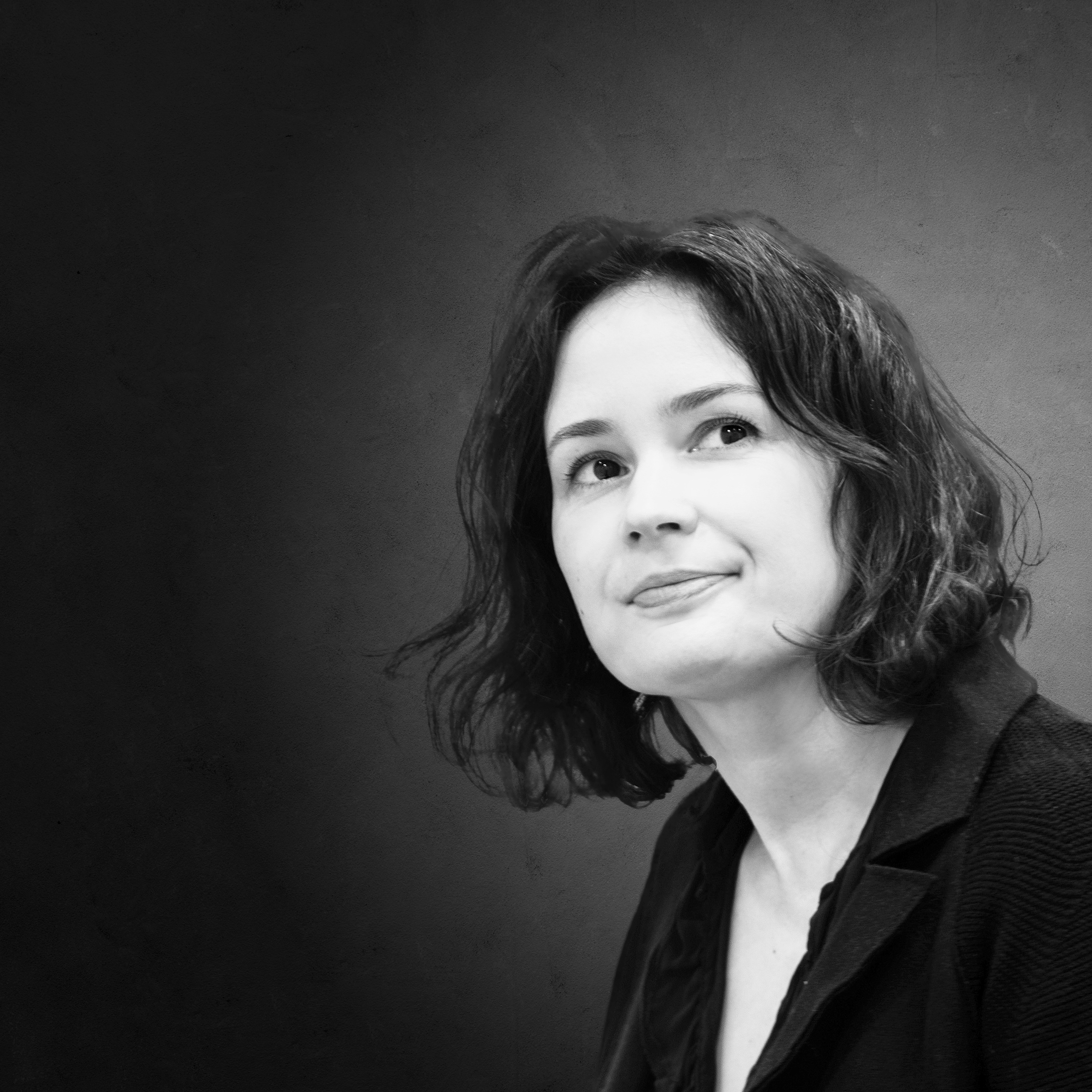 Portrait der Geigerin Patricia Kopatchinskaja. Sie schaut mit angedeutetem Lächeln seitlich an der Kamera vorbei.