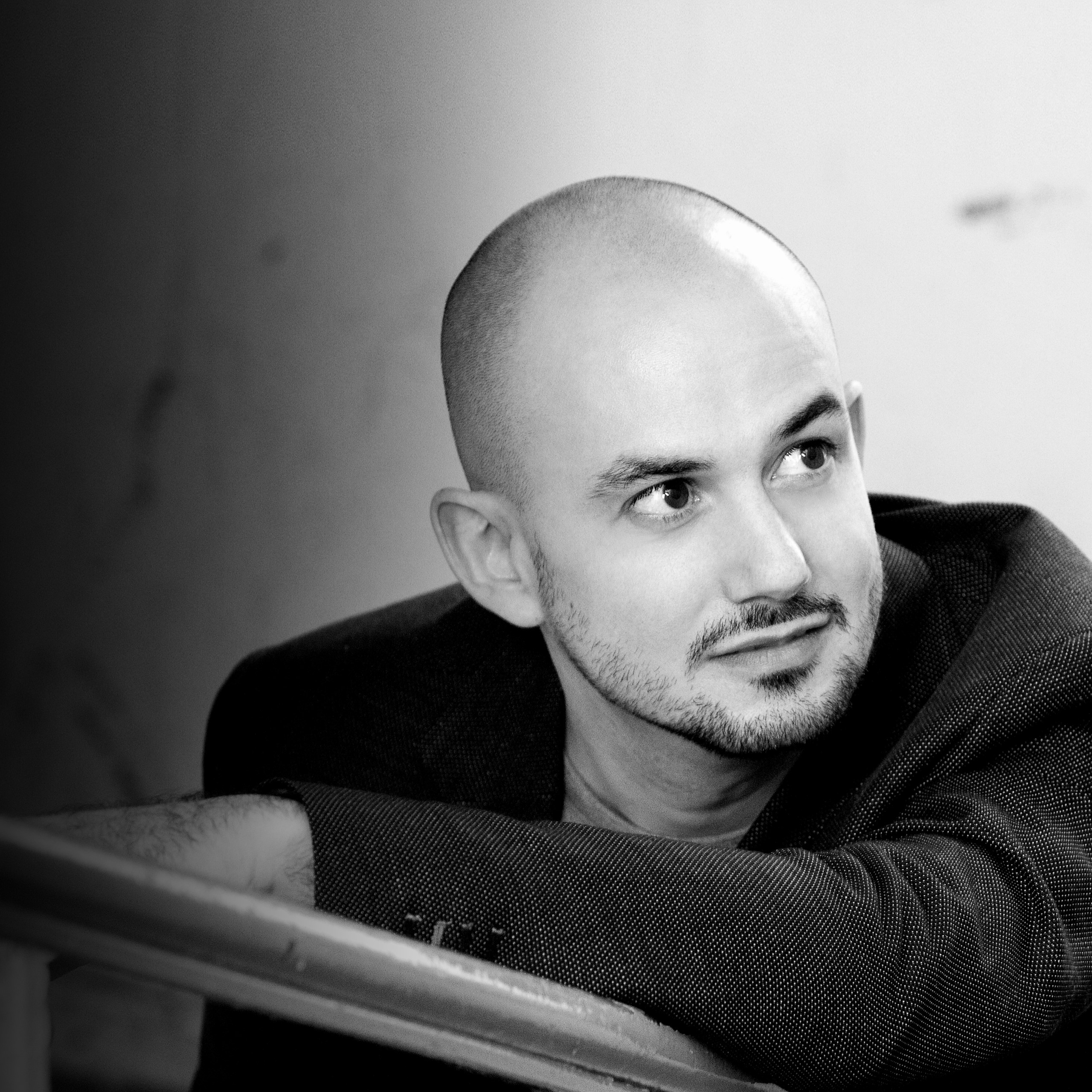 Portrait von Franco Fagioli (Countertenor). Er lehnt mit dem Arm auf einem Treppengeländer, der Blick geht aus dem Bild.
