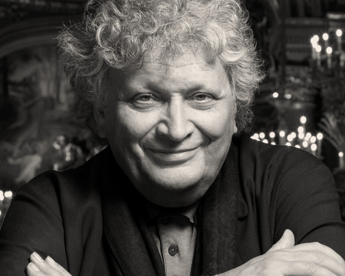 Portrait von René Jacobs. Er hält die Arme vor der Brust verschränkt und blickt in die Kamera.