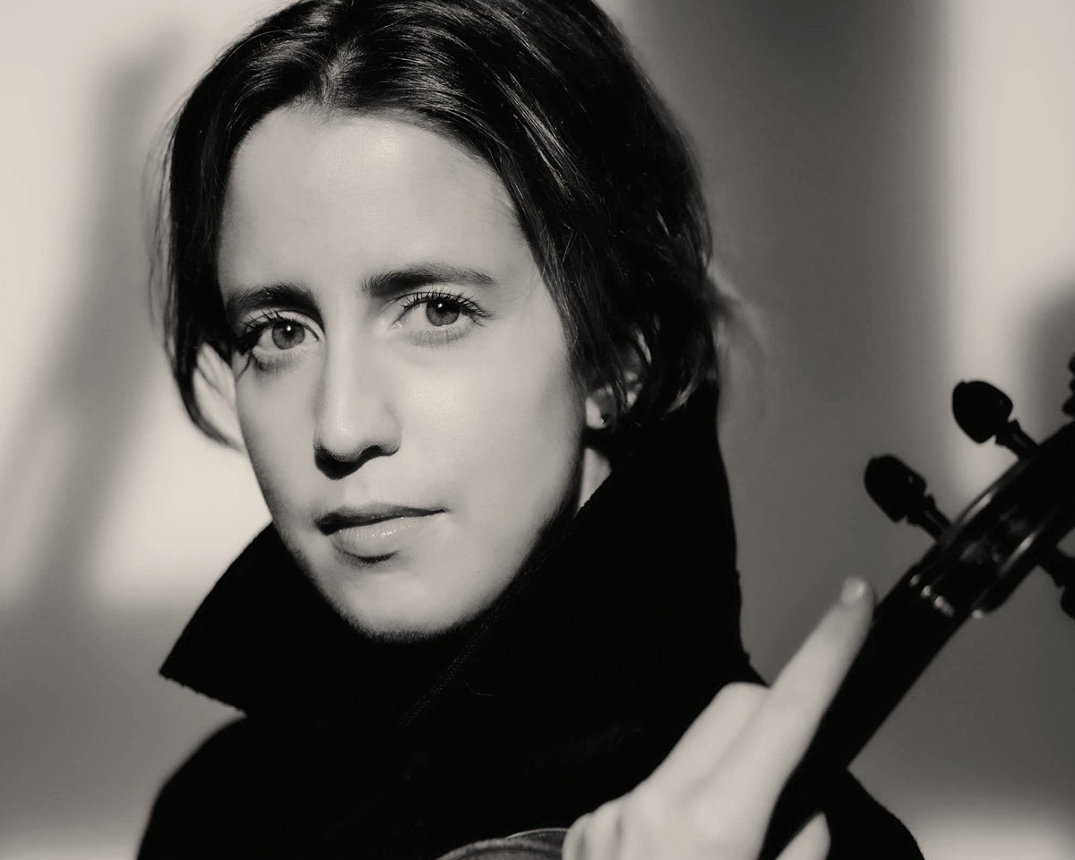 Portrait von Vilde Frang. Sie hält ihre Geige in der Hand und blickt in die Kamera.