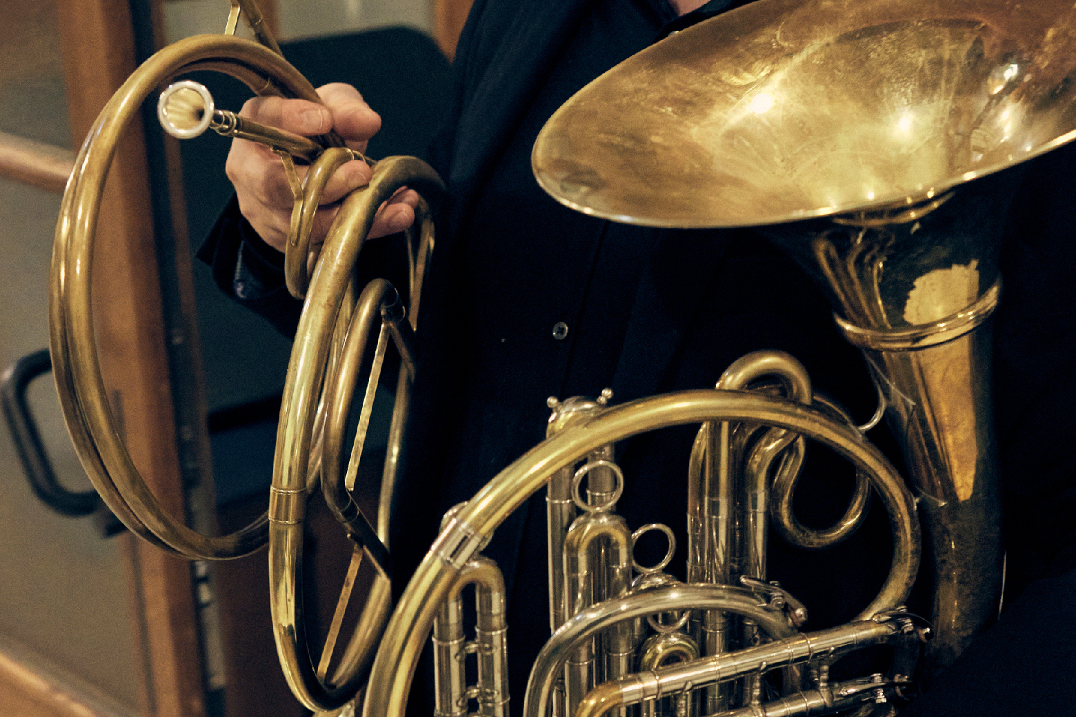 Detailbild: Ein Hornist steht mit seinen beiden Instrumenten bereit.