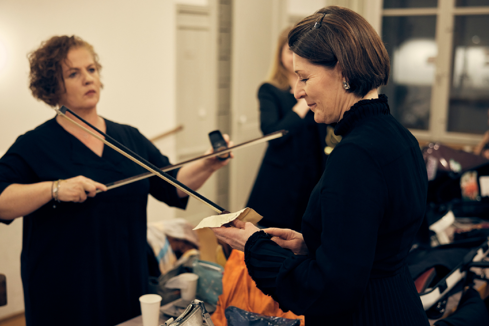 Zwei Geigerinnen bereiten ihre Boegen vor.