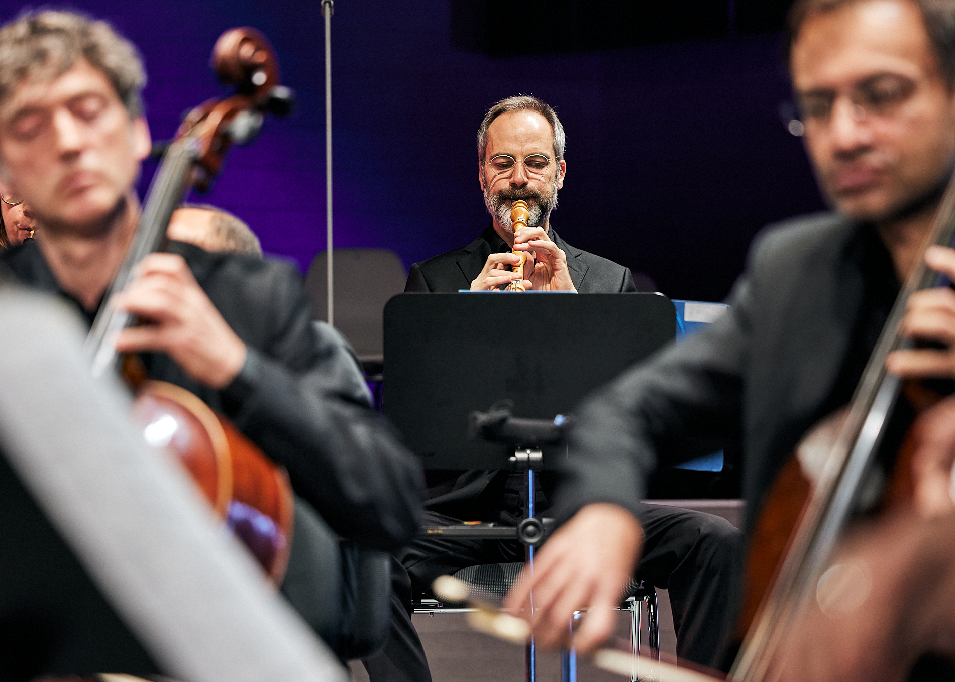 Musiker spielen, zwei Cellisten im Vordergrund, Oboist im Hintergrund