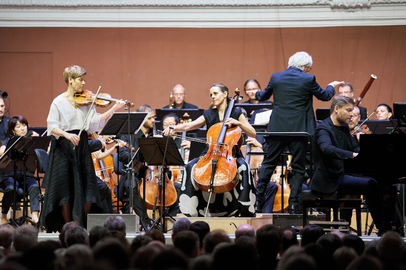 Die Geigerin Isabelle Faust, die Cellistin Sol Gabetta und der Pianist Kristian Bezuidenhout auf der Bühne mit dem Kammerorchester Basel.